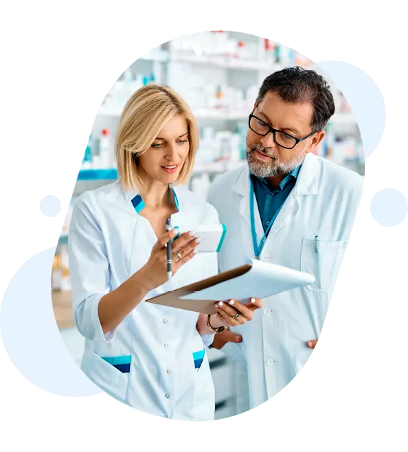 Two pharmacists are discussing a patient's prescription in Higher Crumpsall Pharmacy.