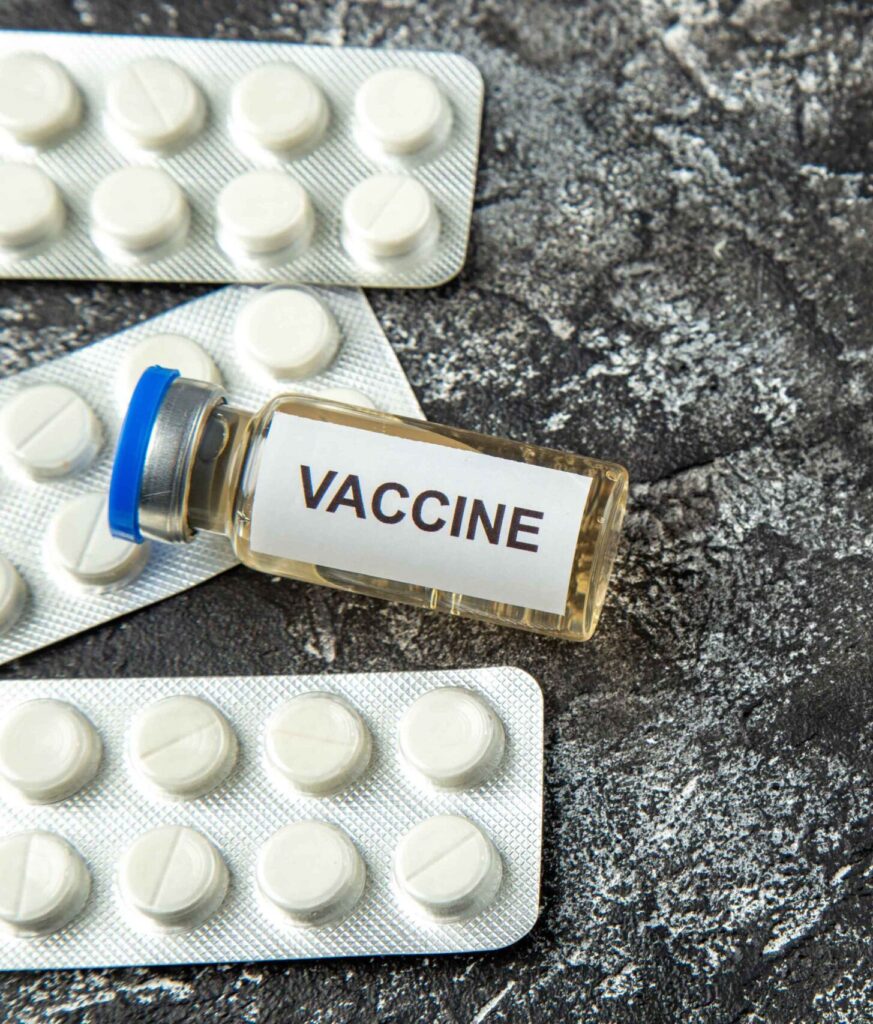 A vaccine vial and pills on a counter in what appears to be a clinic in Crumpsall offering Umrah vaccinations